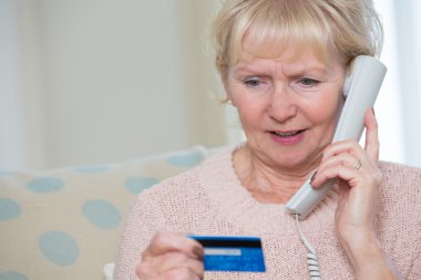 Senior Woman Giving Credit Card Details On The Phone clipart