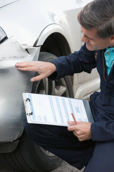 Auto oficina mecânica que inspeciona o dano ao carro e o enchimento em R — Fotografia de Stock