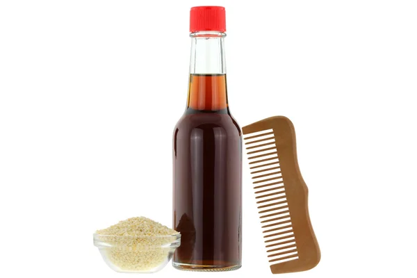 Sesame oil and wooden comb,  ingredient for skin and hair treatment — Stock Photo, Image