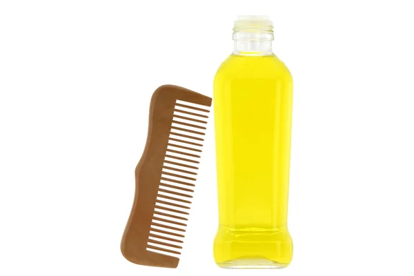 Botella de aceite de oliva y un peine de madera, ingrediente para el tratamiento de la piel y el cabello —  Fotos de Stock