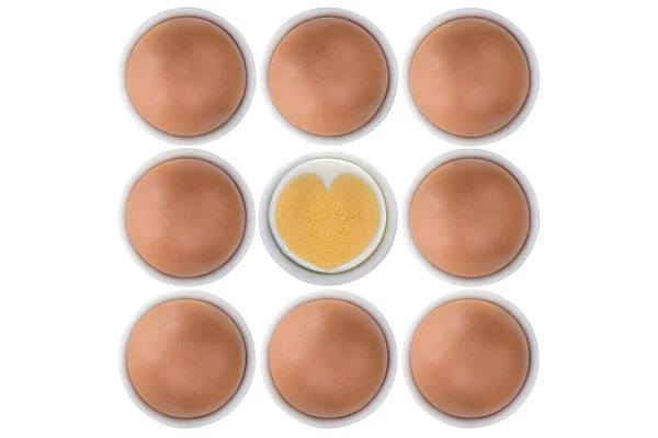 Eggcups pełne świeżych jaj kurzych z jednym Wyświetlono serce ugotowane żółtko — Zdjęcie stockowe
