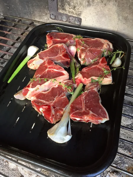 Fresh raw Lamb meat seasoned with garlics, thyme on BBQ nonstick grill drip pan — Stock Photo, Image