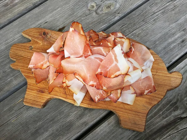 Tissue thin slices Tyrolean Speak, Smoked bacon on wooden cutting board — Stock Photo, Image