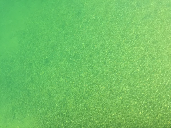 Blå grön nyans av färsk sjön vatten ovanför små sten sten under vattnet — Stockfoto