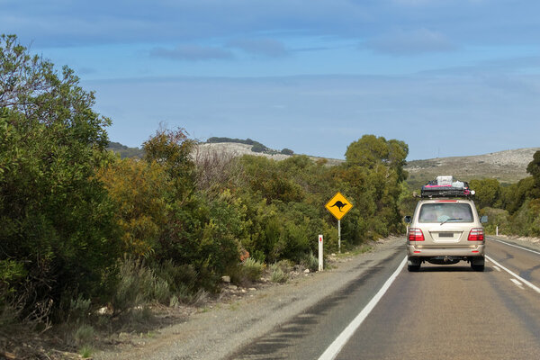 Vehicle with camping equipments on top driving on Cape du Couedic Rd on Kangaroo Island, South Australia