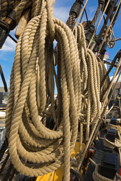 Walcowane grube liny na Starym statku w pobliżu drewnianych knagi — Zdjęcie stockowe