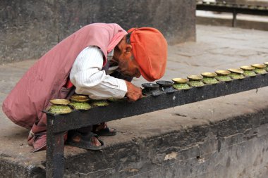 Nepal bir erkek mum yemekleri Patan, Nepal Kumbeshwar Tapınağı'nda yanan kurum kaldırılıyor