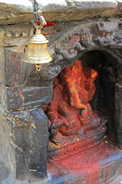 A brass bell in front of a Ganesha Hindu shrine in Kathmandu, Nepal — Stock Photo, Image