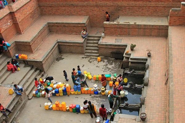 Personas con contenedores de agua para uso doméstico en Sunken Manga Hiti, Nepal — Foto de Stock