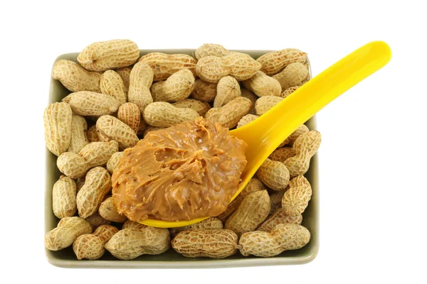 Peanut butter on peanuts isolated on white — Stock Photo, Image