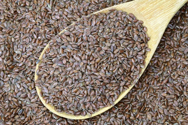 Un cucchiaio di legno pieno di semi di lino (semi di lino ) — Foto Stock
