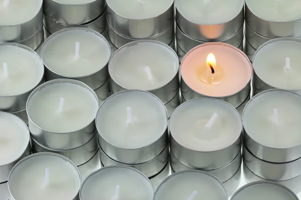 Tea lights candle with one being lit — Stock Photo, Image