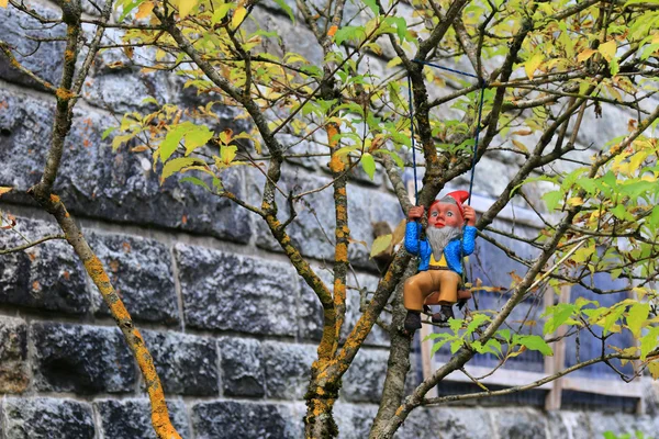 Una pequeña figura enana usada para decorar un árbol en el jardín — Foto de Stock