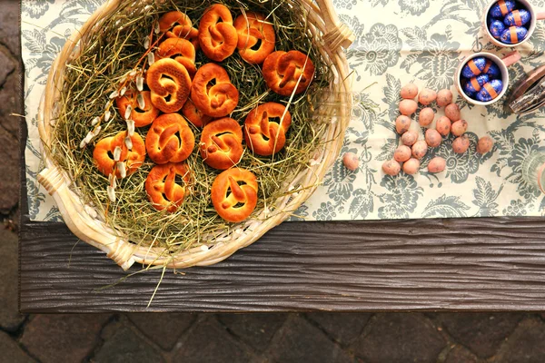 Pretzel on dried hay and Easter chocolate balls — Stock Photo, Image