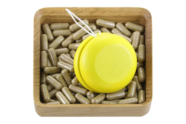Деревянная коробка, полная травяных лекарств с желтым YoYo — стоковое фото