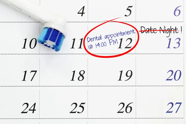 Dental appointment marked on a white calendar with date night being cancelled — Stock Photo, Image