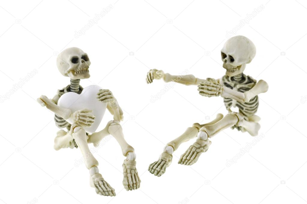 Skeletons sitting together with one holding a white heart