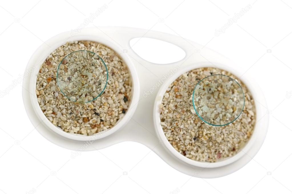 Contact Lens case full of sand and disposable lenses on top