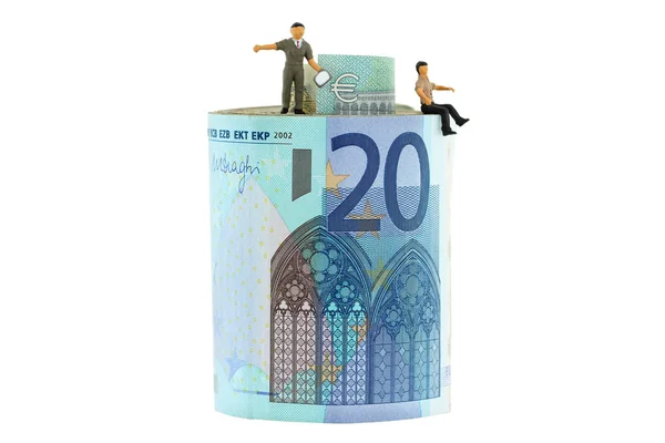 2 hombres en miniatura de pie y sentados en un rollo de billetes en euros —  Fotos de Stock