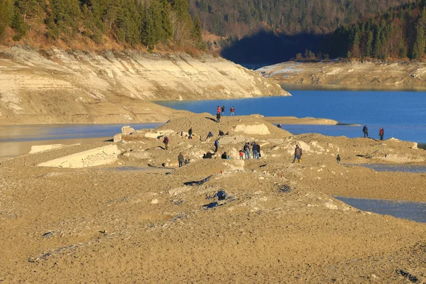 Människor att utforska ruinen av sjunkna gamla byn faller på Sylvenstein Reservoir dam — Stockfoto
