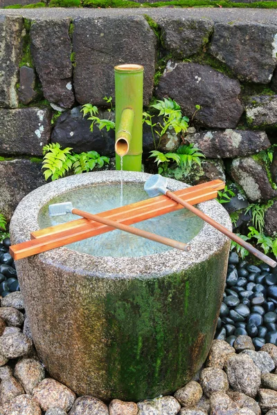 L'eau coule à travers un tuyau en bambou vers un bassin d'eau en pierre, Japon — Photo