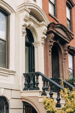 Classic brownstone facades showcase stunning designs and ornate balconies in a vibrant city scene.