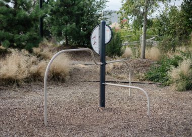 Workout area includes a fitness station set in a green park with trees and open space for exercise.