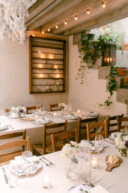 Hoş bir şekilde düzenlenmiş uzun masalar çiçek ve mumlarla dolu. Toplanma için mükemmel bir yer..