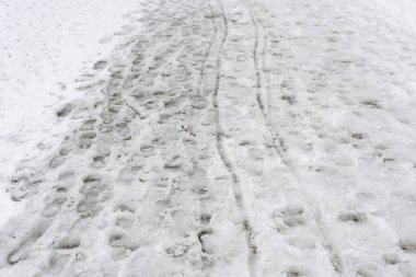 İnsanlar karlı bir yolda yürürken açık havada taze kar üzerinde izler bırakırlar..