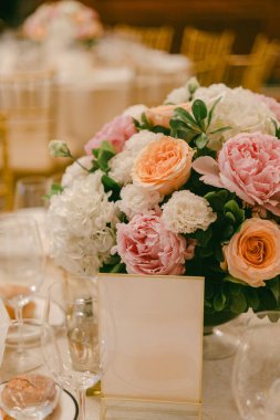 Parlak renklerle dolu bir festivalde büyük bir çiçek aranjmanı yemek masasının ortasına yerleştirilir..