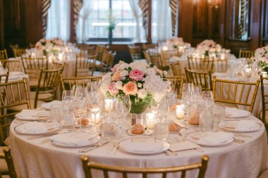 Akşam üzeri dekore edilmiş bir odada resmi bir etkinlik için tabaklar ve çiçeklerle hazırlanır..