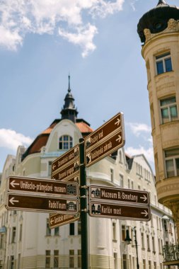 Yönlendirme işaretleri insanları güneşli bir günde arka planda binalar olan bir şehirdeki çeşitli gösterimlere yönlendirir..