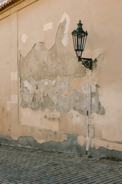 Tarihi bir bölgede gün ışığında sokak ortasında sokak lambası direğiyle duvar boyası soymak..