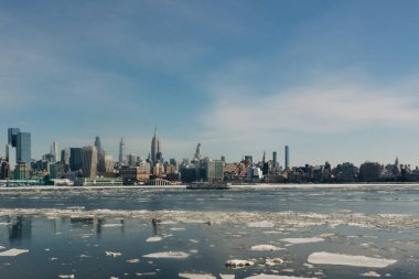 Skyline kışın suda yüzen yüksek binaları ve buzları gösteriyor. Açık gökyüzü ve güneş ışığıyla şehirde çekildi..