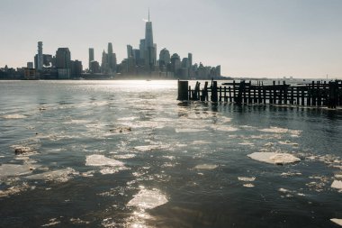New York şehrinin ufuk çizgisi su üzerinde yüzen yüksek binaları ve buzları gösteriyor..