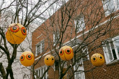 Kentteki şenlikli bir olay sırasında tuğla bir binanın yakınındaki ağaç dallarının arasına yüzler şeklinde fenerler konur..