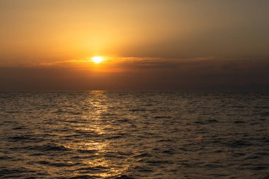 Akşam gökyüzü gün batımında denizin üzerinde