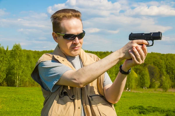 Человек, стреляющий из спортивного пистолета — стоковое фото