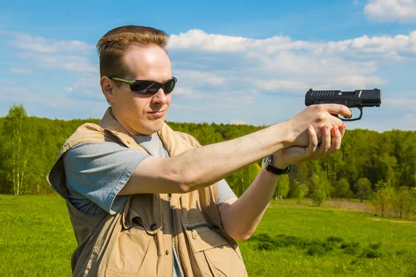 Человек, стреляющий из спортивного пистолета — стоковое фото