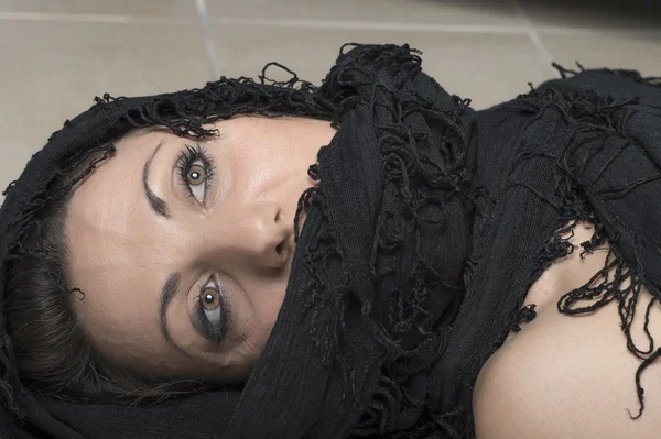 Mulher com rosto envolto em um xale preto — Fotografia de Stock