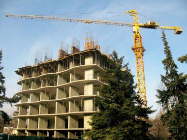 Turnalar mavi gökyüzüne karşı inşaat sahasında çalışıyor