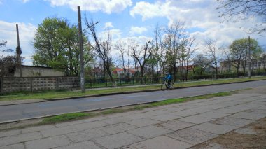 Tek katlı evlerin arasındaki köy yolu yalnız bir bisikletçiyle.