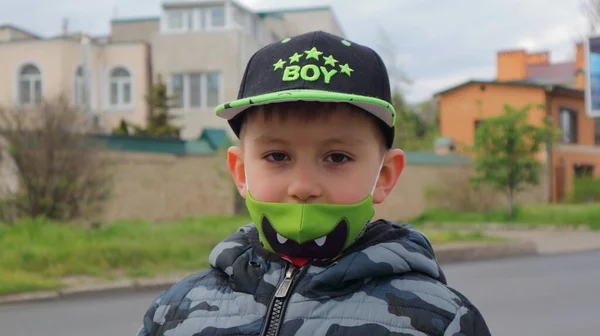 Yüzünde tıbbi koruyucu bebek maskesi olan sevimli bir çocuk..