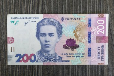The front part of 200 hryvnia banknote close-up with small details. Ukrainian currency on a wooden background.
