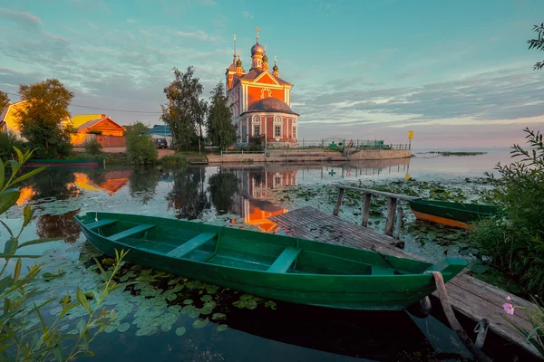 Дерев'яний човен і церква — стокове фото