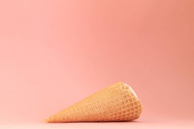 Pembe arka planda izole edilmiş dondurma külahı, tatlı yaz yemekleri konsepti.