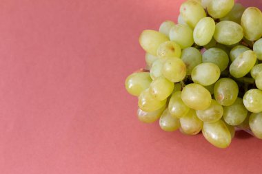 Kahverengi arka planda yeşil üzüm dalı, sağlıklı ve lezzetli yiyecekler.