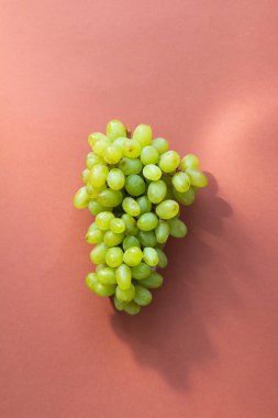 Kahverengi arka planda yeşil üzüm dalı, sağlıklı ve lezzetli yiyecekler.