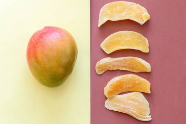 Kahverengi ve sarı renkli arka planda taze mango ve kuru meyve izole edilmiş.
