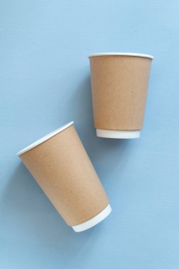 Açık mavi arkaplana karşı gitmek için boş kağıt bardak